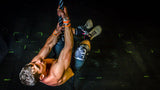man rope climbing using black camo knee sleeves